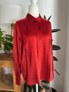 Dark rust or cinnamon colored, pleated, silk blouse. Blouse buttons down the front with hidden buttons, and at the wrist. In overall great condition with no notable flaws, no holes, stains, snags, holes, etc. Label reads, Talbots, size 6, 100% Silk.  Measurements Chest 36in/91.5cm Waist 34in/86.5cm Shoulders 14in/35.5cm Length 24in/61cm *Please keep in mind that unless otherwise noted, all items in my shop are used or previously owned, normal wear and tear is expected, flaws that are noted are range from major to minor, things like a missing stitch here or there my not be included. *Please read all policies on this and our policy page prior to making your purchase. *Please feel free to message me with any questions you may have as returns are not accepted. Response time is typically same d Formal Pleated Silk Blouse, Classic Pleated Blouse For Fall, Classic Pleated Tops For Fall, Fall Classic Pleated Tops, Fall Pleated Blouse For Work, Pleated Solid Color Blouse For Fall, Classic Pleated Button-up Top, Fall Pleated Collared Tops, Classic Pleated Collared Blouse