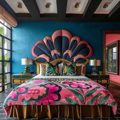 a bedroom with blue walls, pink and green bedspread, gold headboard