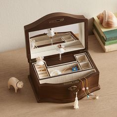 an open wooden jewelry box sitting on top of a table