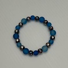 Handmade Elastic Bracelet With Different Size Round Blue Matte Beads Along With Black And Silver, Red And Blue Splatter Beads! Casual Blue Beaded Stretch Bracelet, Blue Beaded Bracelets With Spacer Beads For Party, Blue Beaded Bracelets With 8mm Beads For Party, Blue Round Beads Bracelets For Party, Blue Bracelets With 8mm Beads For Party, Blue Beaded Bracelets For Party, Blue Beads For Jewelry Making, Casual Blue Beaded Bracelets With Spacer Beads, Casual Silver Jewelry With Colorful Beads