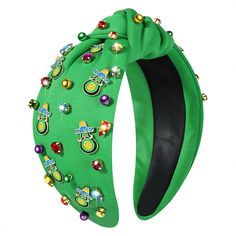 a green headband with lots of colorful beads and bells on the top of it