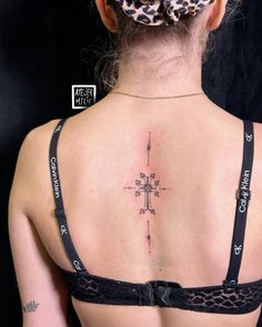 a woman with a cross tattoo on her back