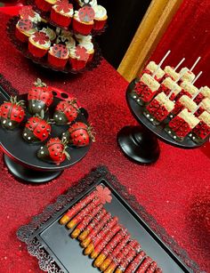 a table topped with lots of cupcakes covered in ladybug frosting