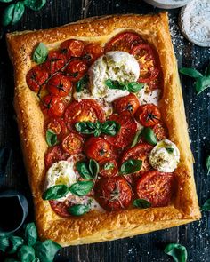 a square pizza with tomatoes, mozzarella and basil leaves on the top crust