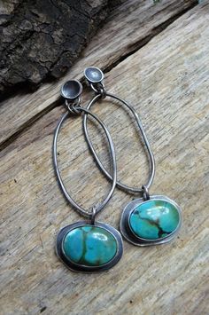 These stunning, natural blue-green turquoise earrings are set in and on sterling silver. They are a very bright blue-green with dapples of yellow, white and black. The natural gemstones measure close to 12x16mm and the overall measurement, from the top of the sterling concave ear wires to the bottom of the set earrings, are 2 3/4 inches and 3/4 inches wide. Each earring weights .2 oz or 6 grams. The silver has been oxidized and offered an industrial polishing. Shipping in the US includes trackin Bohemian Turquoise Oval Earrings, Artisan Turquoise Oval Earrings, Oxidized Turquoise Oval Jewelry, Turquoise Oval Earrings With Natural Stones, Blue Oxidized Dangle Jewelry, Handmade Oval Turquoise Earrings, Turquoise Oxidized Dangle Jewelry, Artisan Turquoise Sterling Silver Earrings, Turquoise Dangle Jewelry With Oxidized Finish