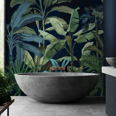 a bathtub in the middle of a bathroom with tropical wallpaper