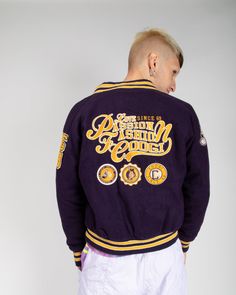 Original coogi 90's purple varsity jacket. with purple/yellow striped cuff, collar and hem, purple button front and two slide-in hand pockets.  felt patches all-over. on right sleeve-boxing gloves, on left sleeve 'cg89', on left breast 'c' with image of a boxing kangaroo. across back 'love since 69, passion fashion coogi" with 3 boxing badges. near perfect condition-hole at rear in arm-pit. mixed chest 46" length 24" sleeve length 30" xl Cotton Varsity Jacket With Letter Patch For Streetwear, Sporty Varsity Jacket With Embroidered Graphics For Streetwear, Sporty Embroidered Varsity Jacket For Streetwear, Sporty Streetwear Varsity Jacket With Embroidered Graphics, Cotton Varsity Jacket With Embroidered Graphics, Throwback Streetwear Varsity Jacket With Ribbed Cuffs, Cotton Varsity Jacket With Logo Patch And Baseball Collar, Throwback Varsity Jacket With Ribbed Cuffs For Streetwear, Cotton Varsity Jacket With Embroidered Graphics For College