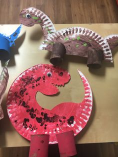 paper plate dinosaurs are sitting on a table