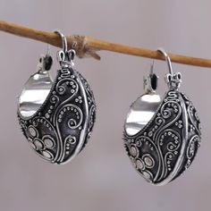 Finely crafted earrings showcase Balinese design as Made Sriasih creates opulent hoops. Sterling arabesques swirl amid silver petals and granules in contemporary heirloom earrings. .925 Sterling silver Elegant Round Earrings With Artistic Design, Ornate Silver Hoop Earrings With Intricate Design, Ornate Silver Hoop Jewelry, Silver Hoop Earrings With Intricate Design As Gift, Ornate Sterling Silver Hoop Earrings With Intricate Design, Silver Filigree Small Hoop Jewelry, Ornate Handmade Hoop Earrings, Handmade Ornate Hoop Earrings, Silver Teardrop Earrings With Artistic Design