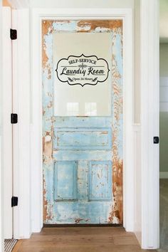 an old blue door with a sign on it that says, the laundry room is open