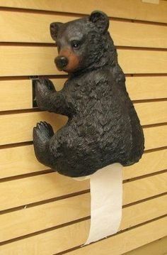 a statue of a bear on a toilet paper holder