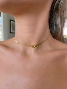 Add a touch of elegance and sweetness to your look with this 18k gold-plated bow choker necklace. Delicately crafted, this necklace features a charming bow design that captures attention and complements any outfit with grace and style. ꧁༺ 𝓝𝓮𝓬𝓴𝓵𝓪𝓬𝓮 𝓓𝓮𝓽𝓪𝓲𝓵𝓼 ༻꧂ ♡ Materials: 18K Gold Plated, Titanium Steel Filled ♡ Waterproof ♡ Anti Tarnish ♡Hypoallergenic ♡ Closure: Lobster claw ♡ Adjustable length: 13 inches + this item comes with a 2-inch extension ♡ Style: Minimalist, Elegant, Tim Elegant Bow Choker As A Gift, Elegant Bow Choker Jewelry, Gold Necklace With Ribbon For Gift, Gold Necklace With Ribbon Perfect For Gifts, Gold Dainty Bow Jewelry, Formal Gold Necklaces With Ribbon, Chic Jewelry With Ribbon For Gift, Dainty Gold Jewelry With Bow Detail, Chic Ribbon Jewelry As A Gift