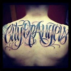 the back of a man's shoulder with an upper and lower arm tattoo that reads city angels