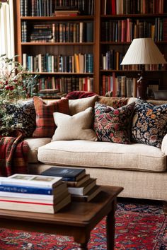 a living room filled with lots of books on top of a wooden table next to a couch