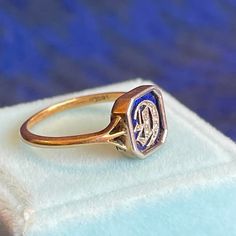 Step into the elegance of the Edwardian era with this distinguished initial ring, a testament to the refinement and artistry of the early 20th century. At its center lies a striking blue enamel panel, meticulously framed in platinum. The focal point of this exquisite piece is a platinum Gothic-style letter "D," adorned with delicate rose cut diamonds that sparkle with a timeless allure.  Crafted from 18 karat gold, this ring is a true masterpiece of design and sophistication. Measuring 8.6 mm from north to south, this ring is a small yet significant statement of elegance and personal touch. Weighing 2.3 grams and sized at 5.5, this ring is not merely a piece of jewelry but a symbol of identity and style. The intricate craftsmanship and luxurious materials make it a perfect heirloom, a cher The Edwardian Era, Green Cocktail, Gold Cocktail Ring, Gold Cocktail, Letter D, Initial Ring, Edwardian Era, Garnet Rings, Rose Cut Diamond