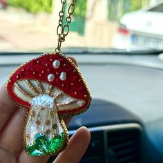 a hand holding a keychain with a mushroom on it's back end