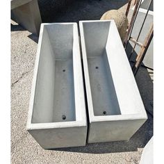 two concrete planters sitting next to each other