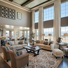 a living room filled with furniture and large windows