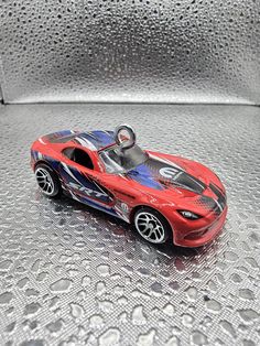 a red toy car on a shiny surface