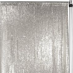 a white curtain with silver sequins hanging from it's side, in front of a white background