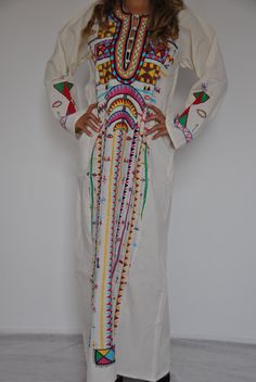 "This beautiful Vintage Kaftan Maxi dress is 100% Bedouin hand embroidered. It is the perfect dress for your summer party or night out. This dress is hand stitched by a group of 3 girls in Siwa Egypt, and takes around four weeks to make. This dress is literally a piece of art with the quality, colourfulness, and design of the embroidery. IMPORTANT NOTE : This dress is Vintage and is made by a group of girls working on it over a long period of time, and thus there might be some very minor imperfe Bohemian Maxi Dress For Festivals And Traditional Ceremonies, Traditional Embroidered Multicolor Maxi Dress, White Kaftan With Traditional Patterns, Maxi Length, Embroidered White Traditional Maxi Dress, Traditional Patterned Dresses For Summer Ceremonies, Traditional Multicolor Maxi Dress With Floral Embroidery, Summer Dresses With Traditional Patterns For Ceremonies, White Bohemian Maxi Dress For Traditional Ceremonies, White Dress With Traditional Patterns For Spring