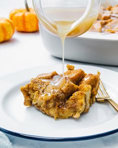 a white plate topped with food next to a glass of orange juice and a bowl of oatmeal