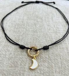 Simple black thread with a moon white/gold pendant White Moon Charm Necklace, White Crescent Handmade Necklace, Handmade White Crescent Necklace, White Adjustable Necklace With Moon Charm, Adjustable White Necklace With Moon Charm, Handmade White Moon Shaped Necklace, Handmade White Moon-shaped Necklace, White Adjustable Choker Jewelry, Minimalist White Crescent Necklace