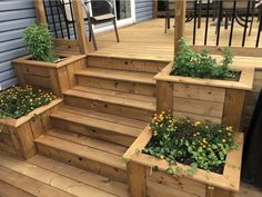 wooden steps with planters and flowers in them on the outside of a home's deck