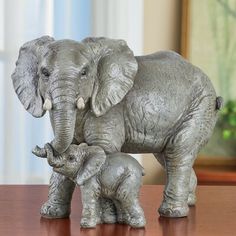 an elephant and her baby are standing on a table