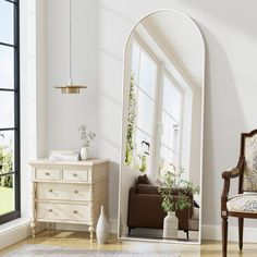 a living room with an arched mirror and furniture