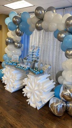 a table topped with balloons and snowflakes on top of a wooden floor