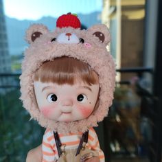 a doll with a bear hat on top of it's head and overalls