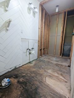 an unfinished bathroom with wood flooring and white walls