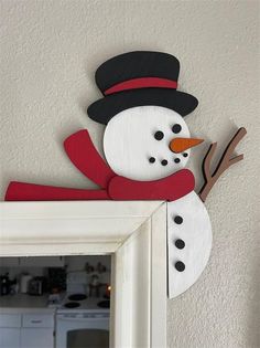 a wooden snowman hanging from the side of a wall