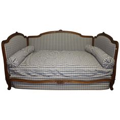 a dog bed with blue and white checkered sheets on it's back end