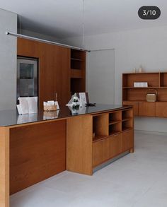 an empty kitchen with wooden cabinets and counter tops, including a microwave in the center