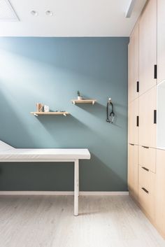 a room with blue walls and shelves on the wall, along with a white table