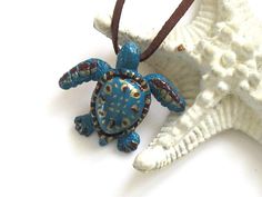 Flat Rate Shipping $5.95 - Orders Over $50 Ship FREE Hand sculpted sea turtle from polymer clay Featuring a lovely dark turquoise, brown and gold color combo Limited edition A beautiful sea turtle with a gorgeous hand painted design and texture is the focal of this necklace. This unique necklace is a must have for the sea turtle lover. You won't find this in the stores. Guaranteed! The pendant hangs from a lovely brown suede cord. The cord doesn't have a clasp, so you can tie this necklace as lo Cthulhu Jewelry, Sea Turtle Jewelry, Sea Turtle Gifts, Octopus Jewelry, Pirate Jewelry, Sea Turtle Necklace, Turtle Jewelry, Turtle Gifts, Seahorse Pendant