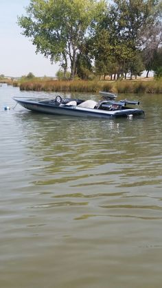 a boat is sitting in the water near some trees