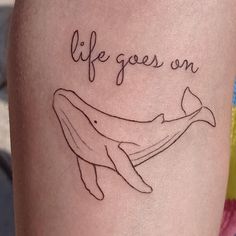 a tattoo that says life goes on with a humpback whale in the background