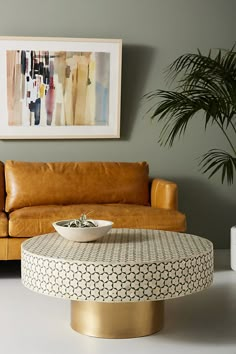 a living room with a couch, coffee table and potted plant