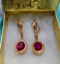 This is  gorgeous pair of oval faceted ruby earrings. Set in beautifully detailed heavily plated 14k gold over sterling silver. For pierced ears, lever back hook style. Each oval lab created ruby measures 10mm x 8mm. Earrings measure 4 cm (1 1/2") from top to bottom. Vintage from the 1950's. Please see the fine detail of these beauties! Local jeweler estimated the value of these earrings to be approx $275.00. Lovely gift for that special lady with a July birthday! I ship promptly! Vintage Gold Gemstone Earrings, Victorian Oval Earrings For Anniversary, Victorian Jewelry With Oval Matching Earrings, Classic Ruby Earrings For Formal Occasions, Elegant Oval Clip-on Jewelry, Vintage Oval Earrings Hallmarked, Vintage Oval Hallmarked Earrings, Ornate Oval Earrings For Anniversary, Ornate Gemstone Earrings For Formal Occasions