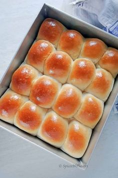 a metal pan filled with bread rolls on top of a table