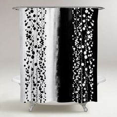 a black and white shower curtain with water drops on the bottom, next to a bathtub