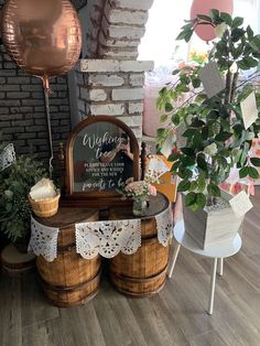 a wooden table topped with baskets filled with flowers and greenery next to a brick wall