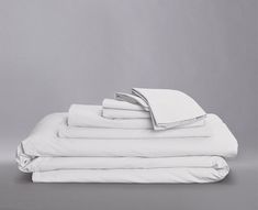 a stack of white sheets folded on top of each other in front of a gray background