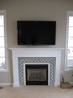 a flat screen tv mounted above a fireplace in a living room