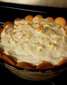 a pie sitting on top of an oven in a glass dish with white frosting