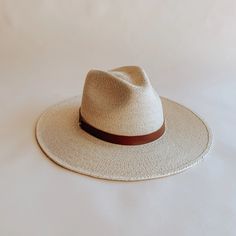 The Soleil straw fedora was thoughtfully designed to be an approachable, ready to wear style that effortlessly tops off any warm weather outfit. Featuring a flat, stiff brim size that measures 3 1/2", and a classic pinch crown fedora shape, the Soleil shines for everyday wear, offering UPF 50+ sun protection. Sustainably harvested tripilla palm straw is lightly toasted, then intricately handwoven by artisans in Puebla, Mexico to create each Soleil style, part of our premium straw hat collection. Adding to the versatility of our headwear, the Soleil's removable and interchangeable, genuine leather hatband with its gold hardware finish has become a Leah hat signature. Available with an adjustable inner, cotton sweatband for a more comfortable fit. Each hat comes with a genuine brown leather Classic Flat Brim Fedora For Spring, Classic Boater Hat For Spring, Chic Panama Hat With Short Brim, Chic Short Brim Panama Hat For Everyday, Chic Everyday Panama Hat With Short Brim, Chic Wide Brim Boater Hat For Daily Wear, Chic Everyday Fedora With Flat Crown, Classic Spring Fedora With Flat Crown, Chic Panama Hat With Flat Crown For Spring