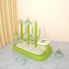 a green and white counter top with utensils in the shape of cactuses